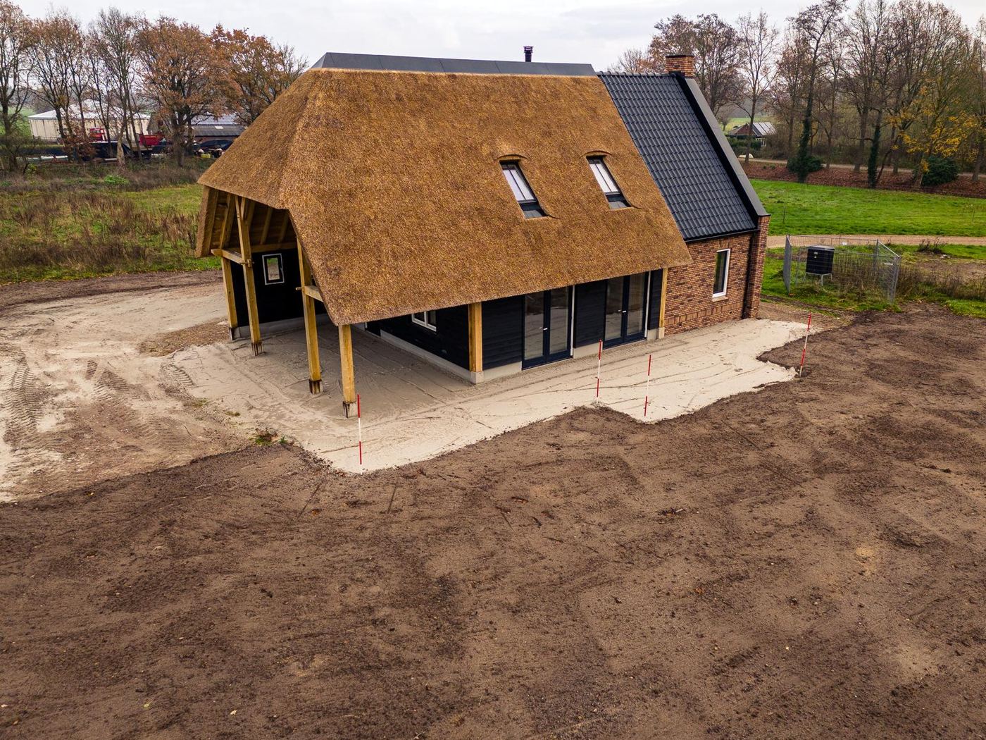 Nieuwe woning met rieten kap en bakstenen gevel, gezien van boven