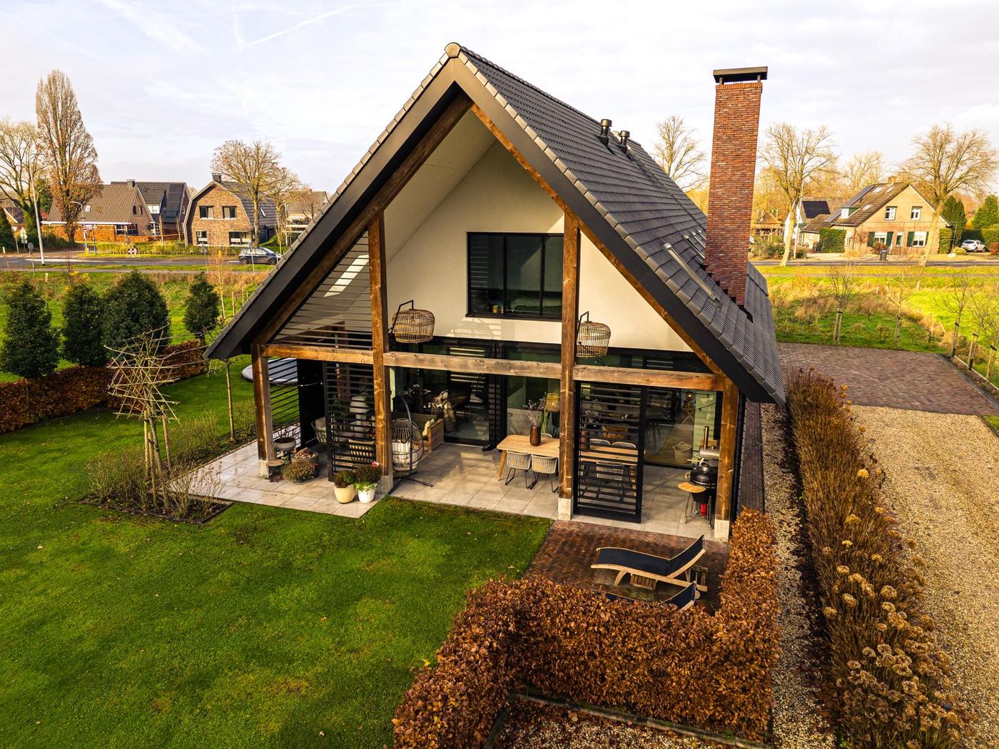 Donkere schuurwoning met zonnepanelen en een overdekt terras, gezien van boven