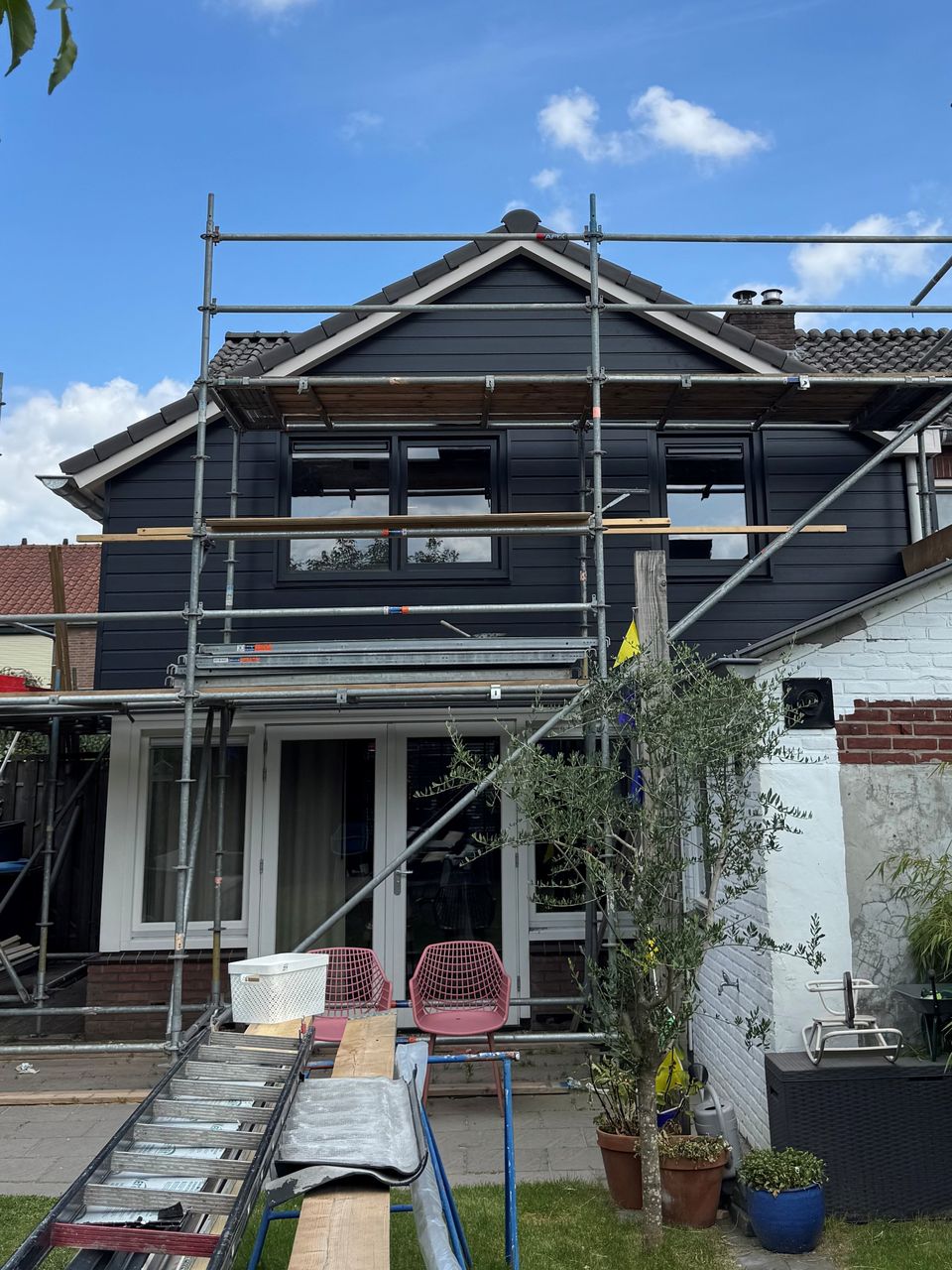 Voor: dezelfde achtergevel tijdens de bouw, met de steiger nog tegen de gevel